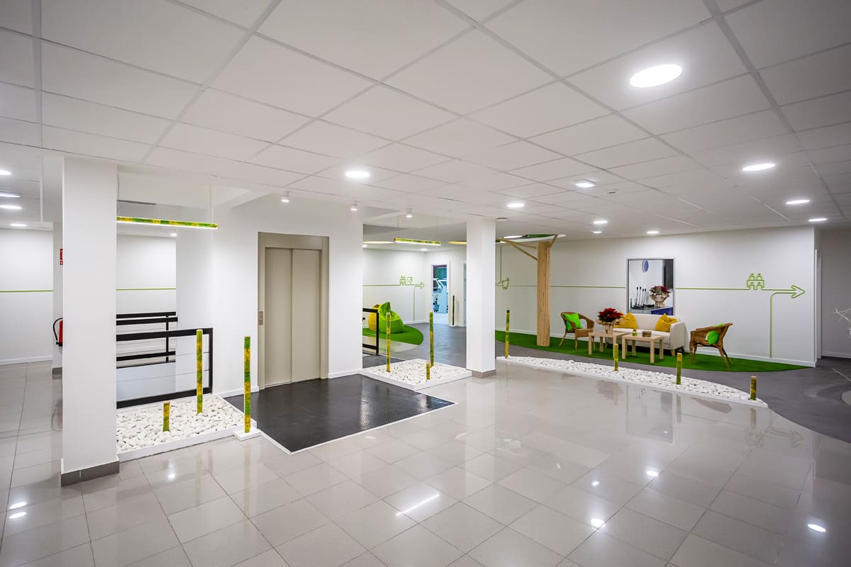 Área de recepción y espera en Laboratorio Dental Astur con diseño moderno y decoración en tonos verdes.